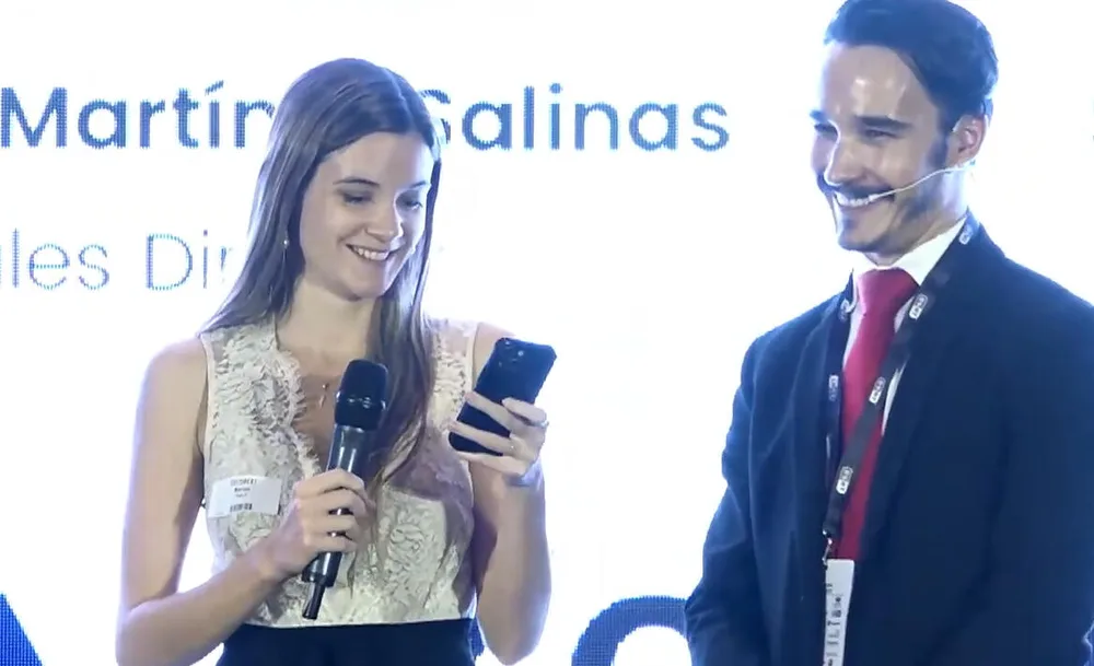 Antonio junto a una participante que sostiene un móvil durante una experiencia de mentalismo