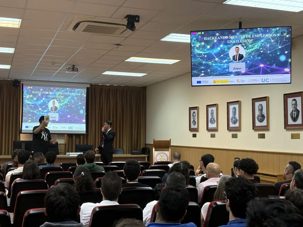Antonio ante asistentes en una sala, con una proyección sobre ingeniería social